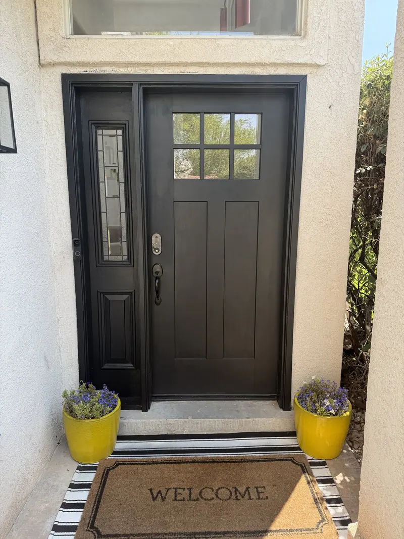 Dark entry door with glass panels and a matching sidelight.
