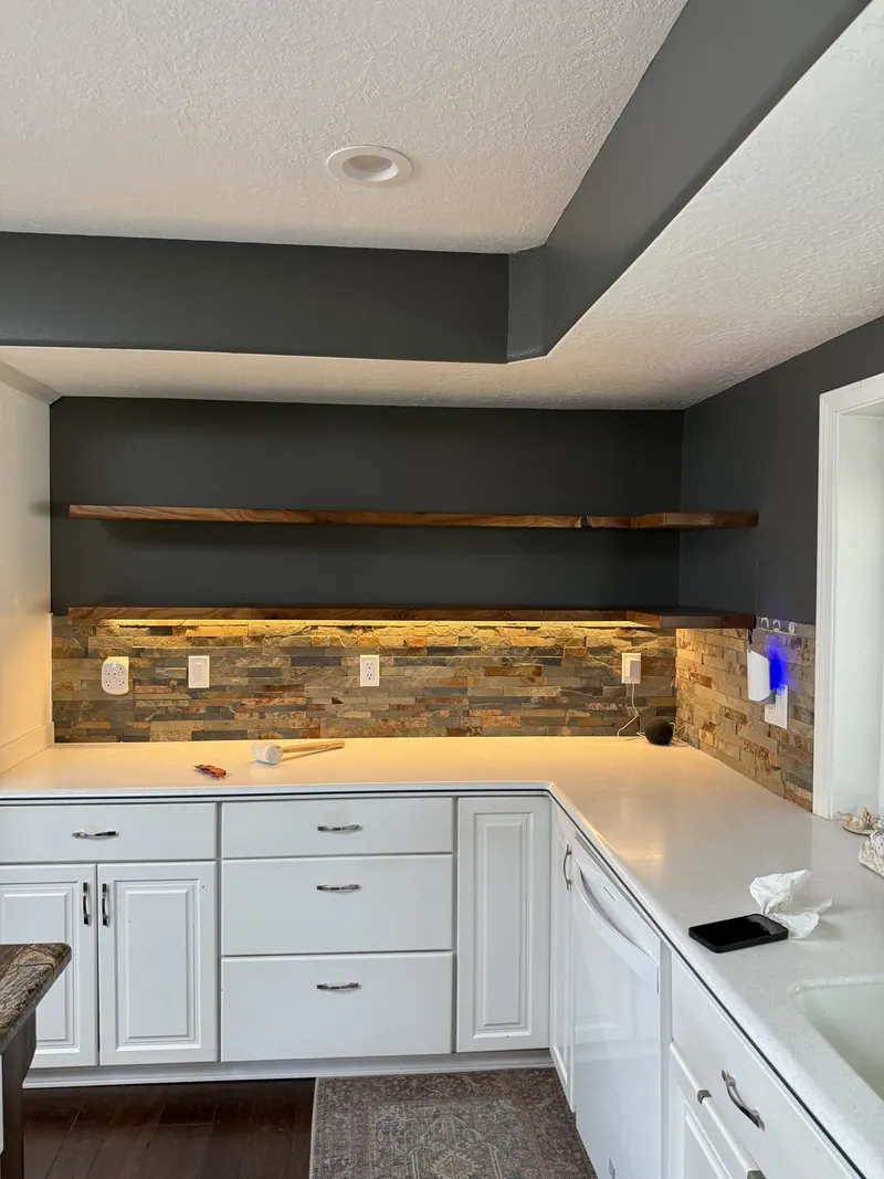 White cabinetry, wood shelving and contrasting wall finishes.